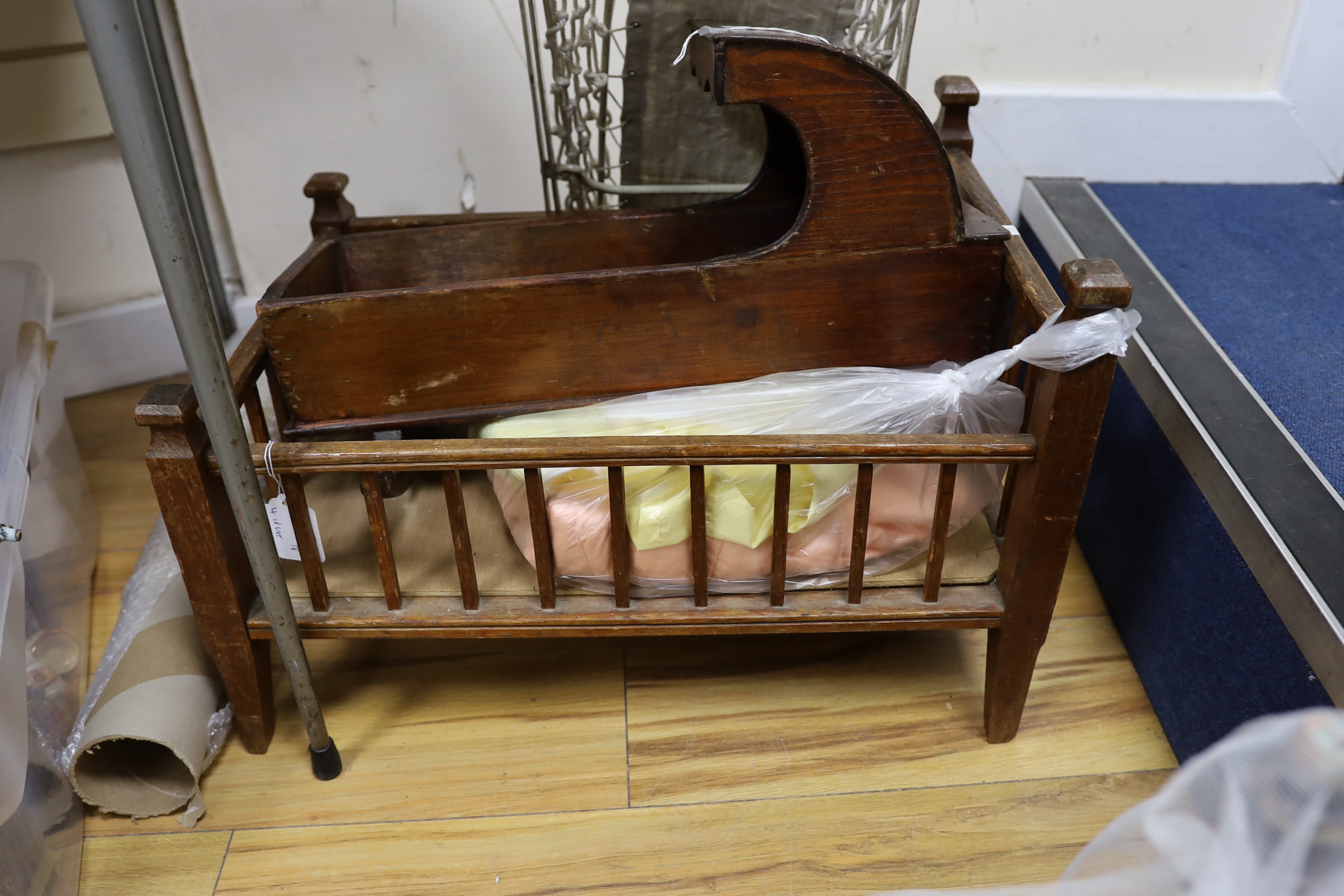 A mahogany crib, a doll's bed and bedding and a painted wooden rocking cradle and a Victorian cast iron crib